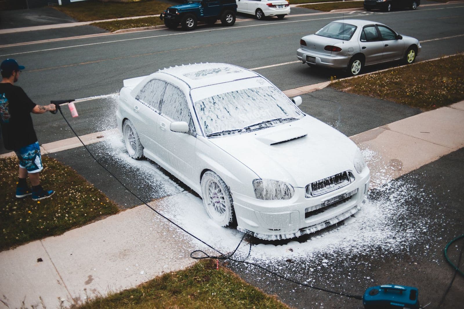 Car being cleaned with a pressure washer gun, showing how does a pressure washer work
